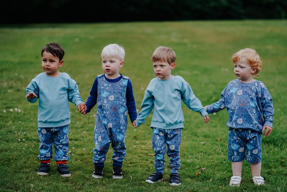 4 Boys holding hands in a field