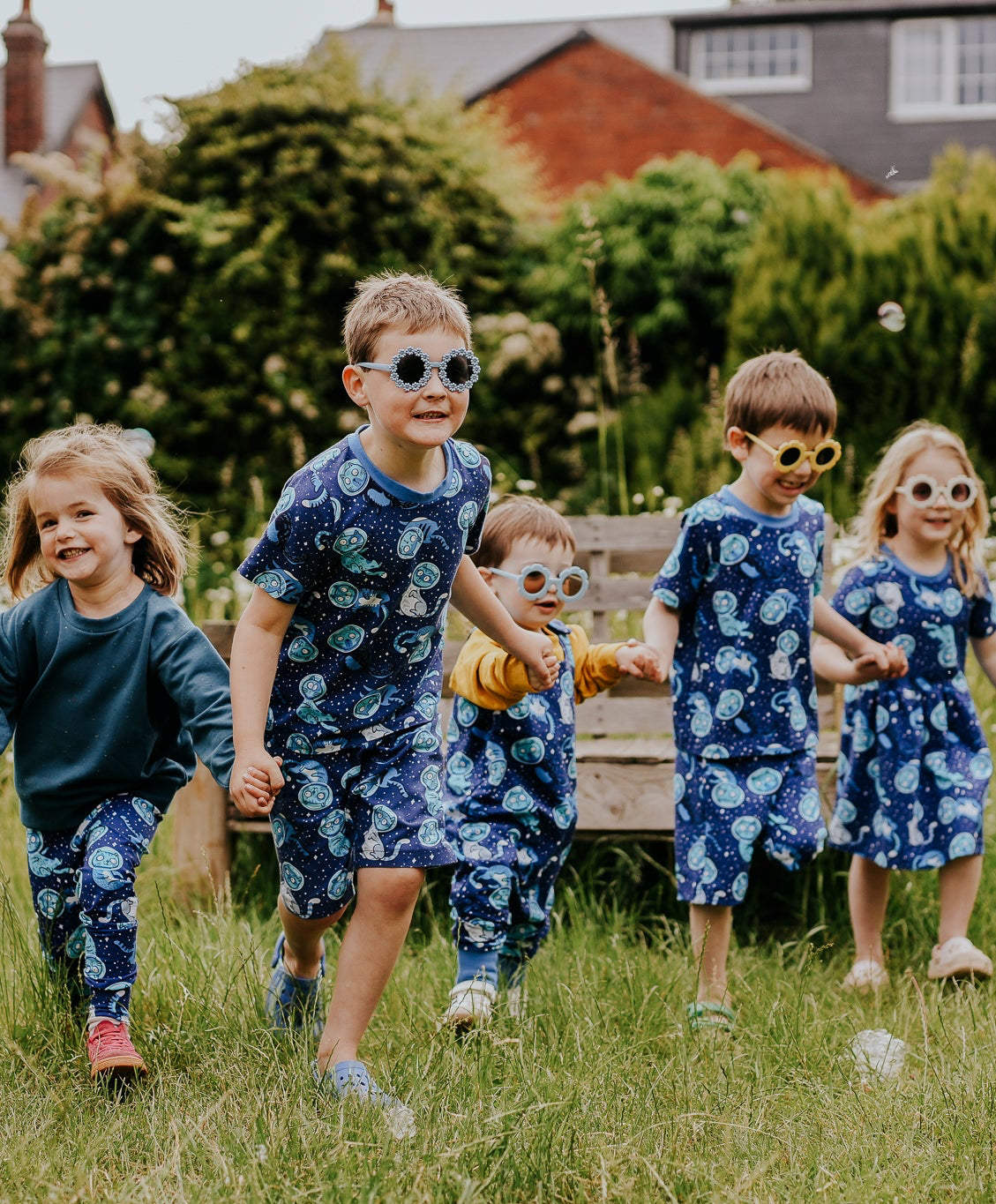 Children dressed in handmade clothing in a SpaceCats print 