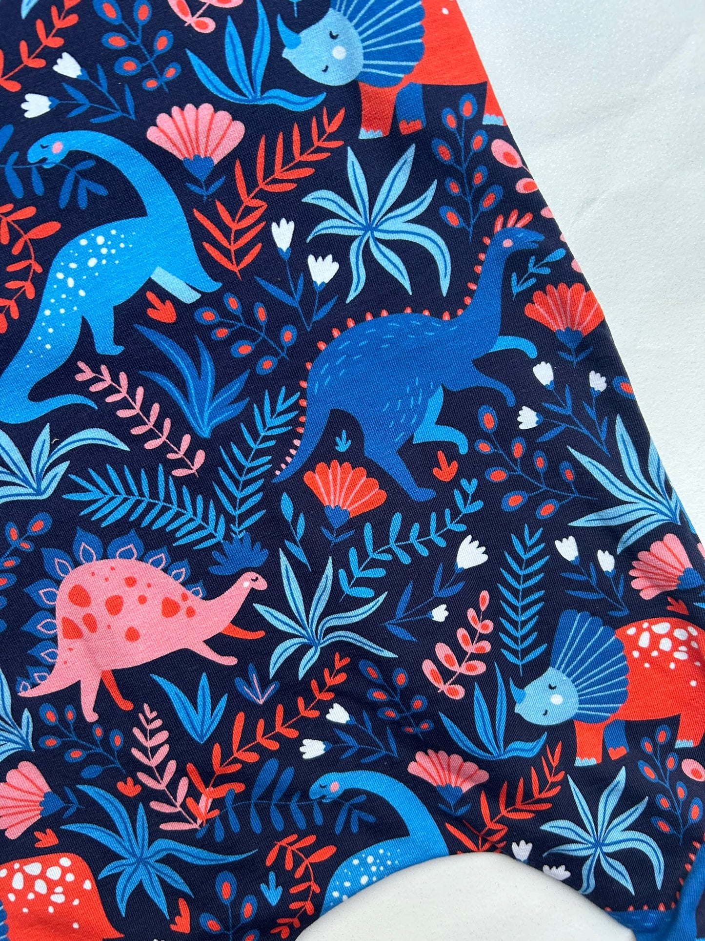 Handmade in Sheffield, super soft handmade jersey baby and toddler romper in blue and red dinosaur print. The cuff harem rompers feature super soft fold up ankle cuffs, so they grow with your child. Made from soft jersey cotton.