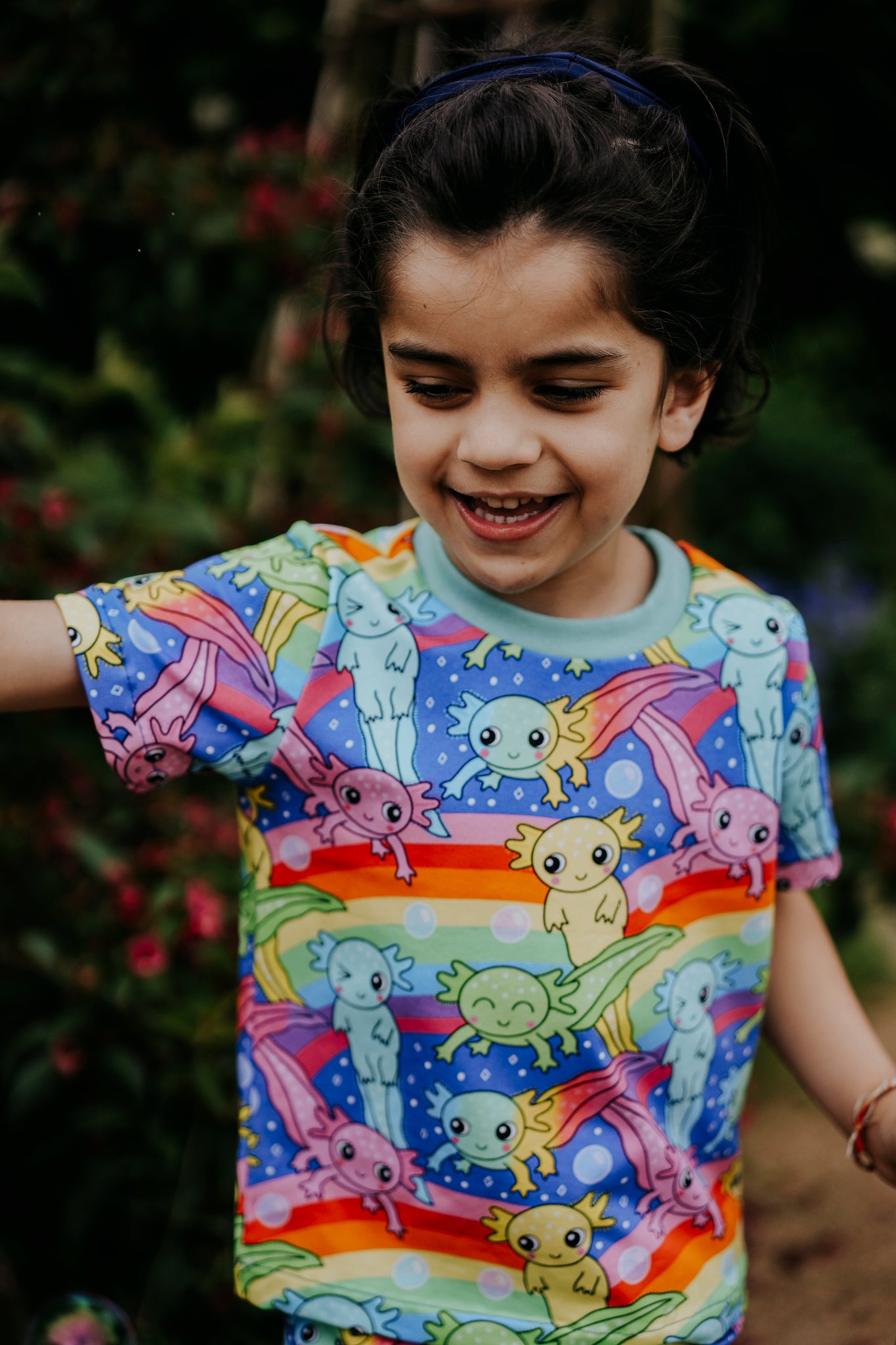 Picture of a boy wearing a handmade colourful rainbow Axoltl T-Shirt